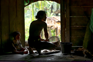 Adulte et enfant de la tribu des Mentawai préparant le repas